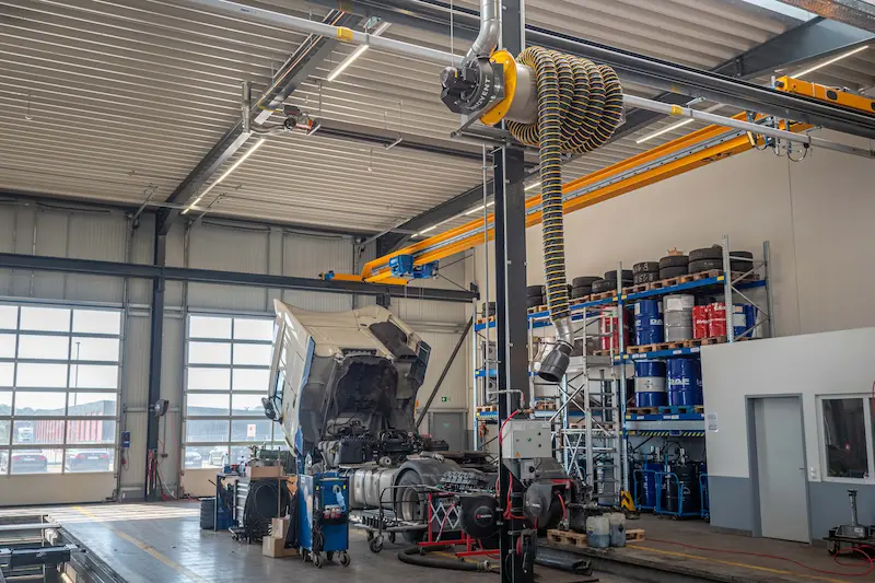 Enrollador de manguera MER Plymovent para extracción de gases de escape en taller de camiones y buses